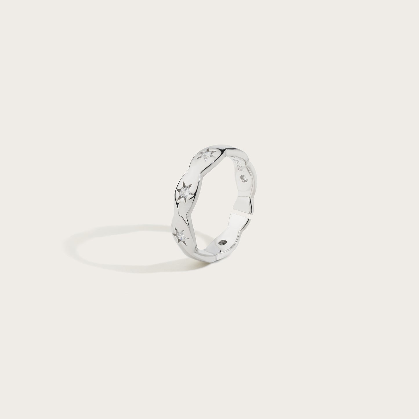 Silver ring with a unique design on a light gray background