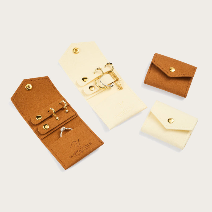 Set of brown and beige jewelry cases with gold accents on a light gray background