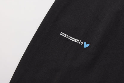 Black fabric with 'unstoppable' text and blue heart symbol on a white background