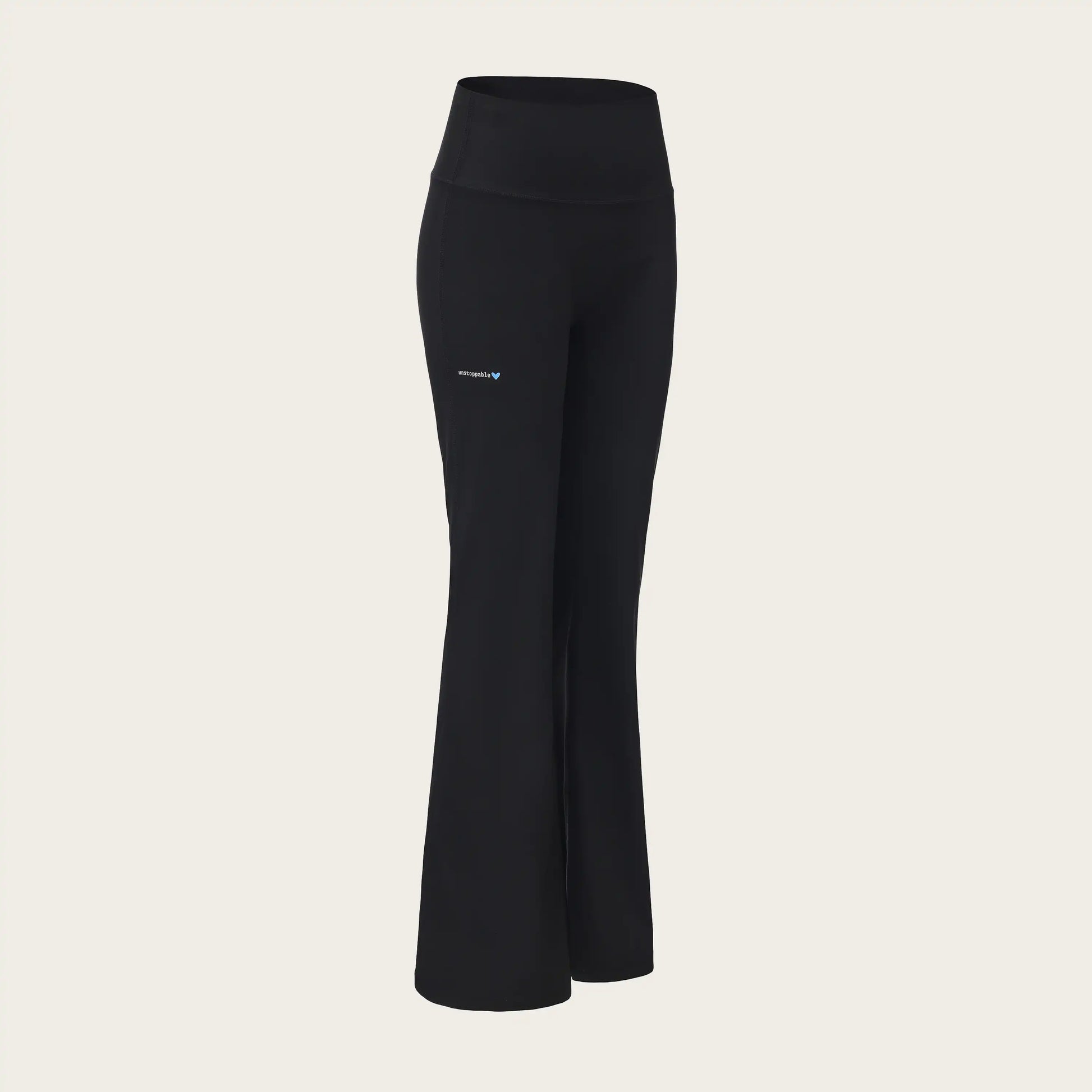 Black pants with a brand logo on a beige background