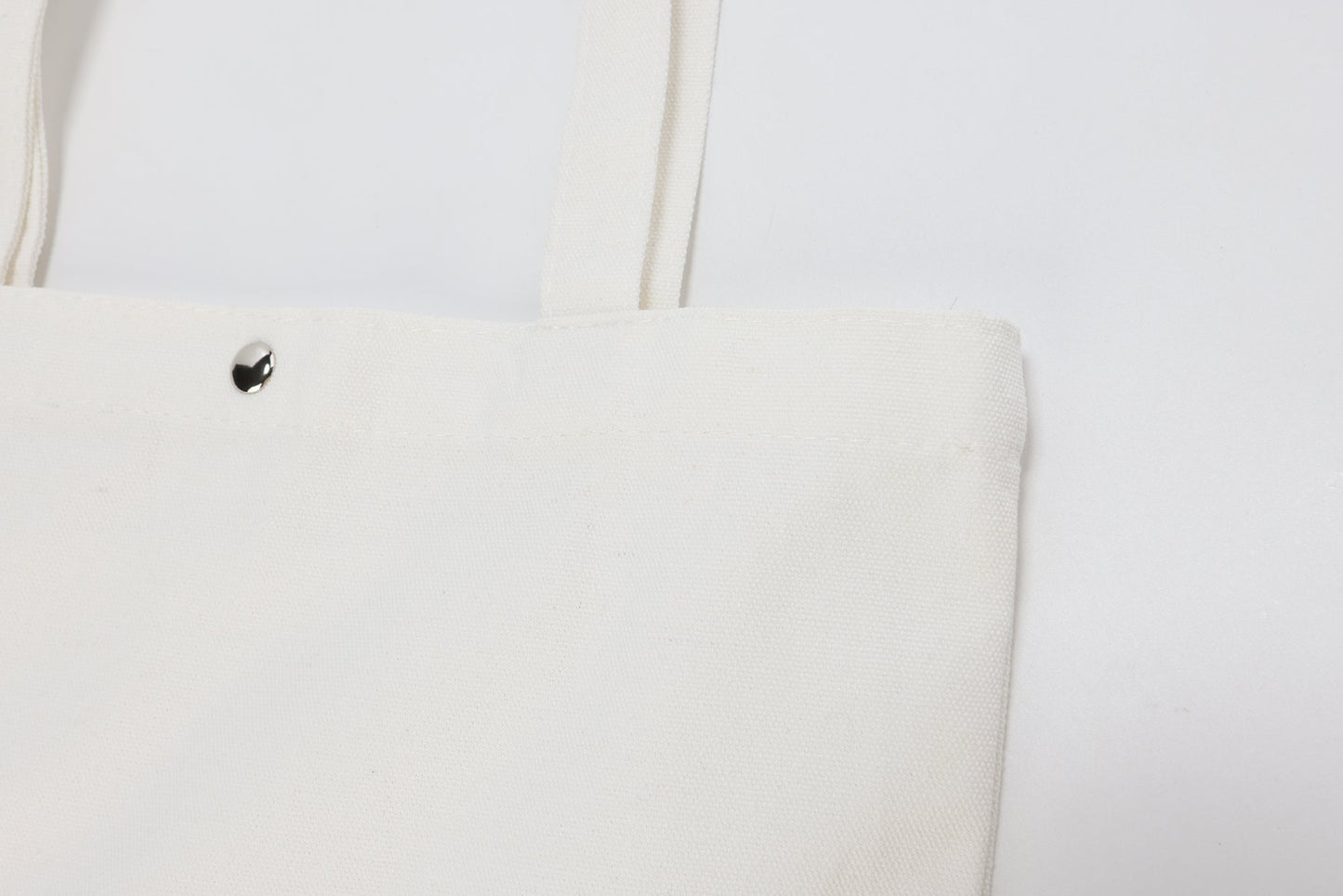 White canvas tote bag with a magnetic closure, perfect for wholesale or everyday use.