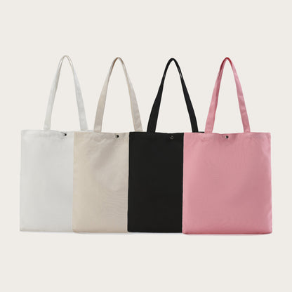 Unstoppable Collective canvas tote bag with a magnetic closure, in white, beige, black and pink.